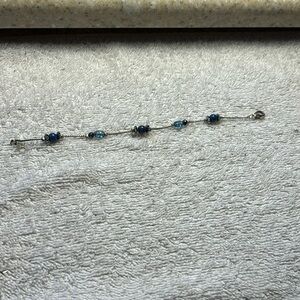 Silver tone and blue beaded bracelet with lobster claw clasp. 8” overall length.